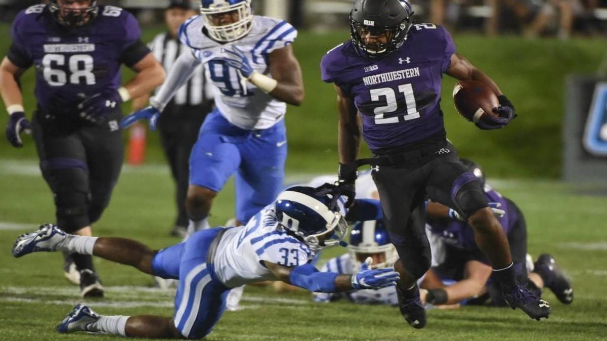 Northwestern running back Justin Jackson (21) runs against Duke safety Deondre Singleton (33) during the first quarter in Evanston, Ill.