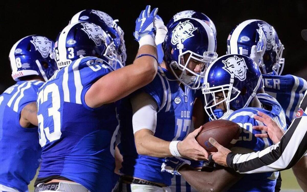 Duke quarterback Daniel Jones (17) is mobbed by teammates after scoring a second-quarter touchdown against the Tar Heels at Walllace Wade Stadium.