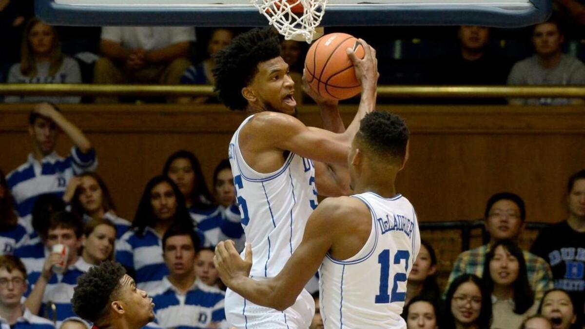 Duke forward Marvin Bagley III snatches a rebound from teammate forward Javin DeLaurier, right, and Saint Francis guard Andre Wolford, left, on Dec. 5.