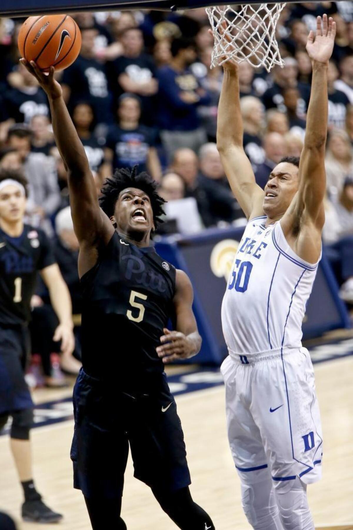 Pittsburgh's Marcus Carr, left, shoots while Justin Robinson defends in the Blue Devils’ 87-52 win on Wednesday.