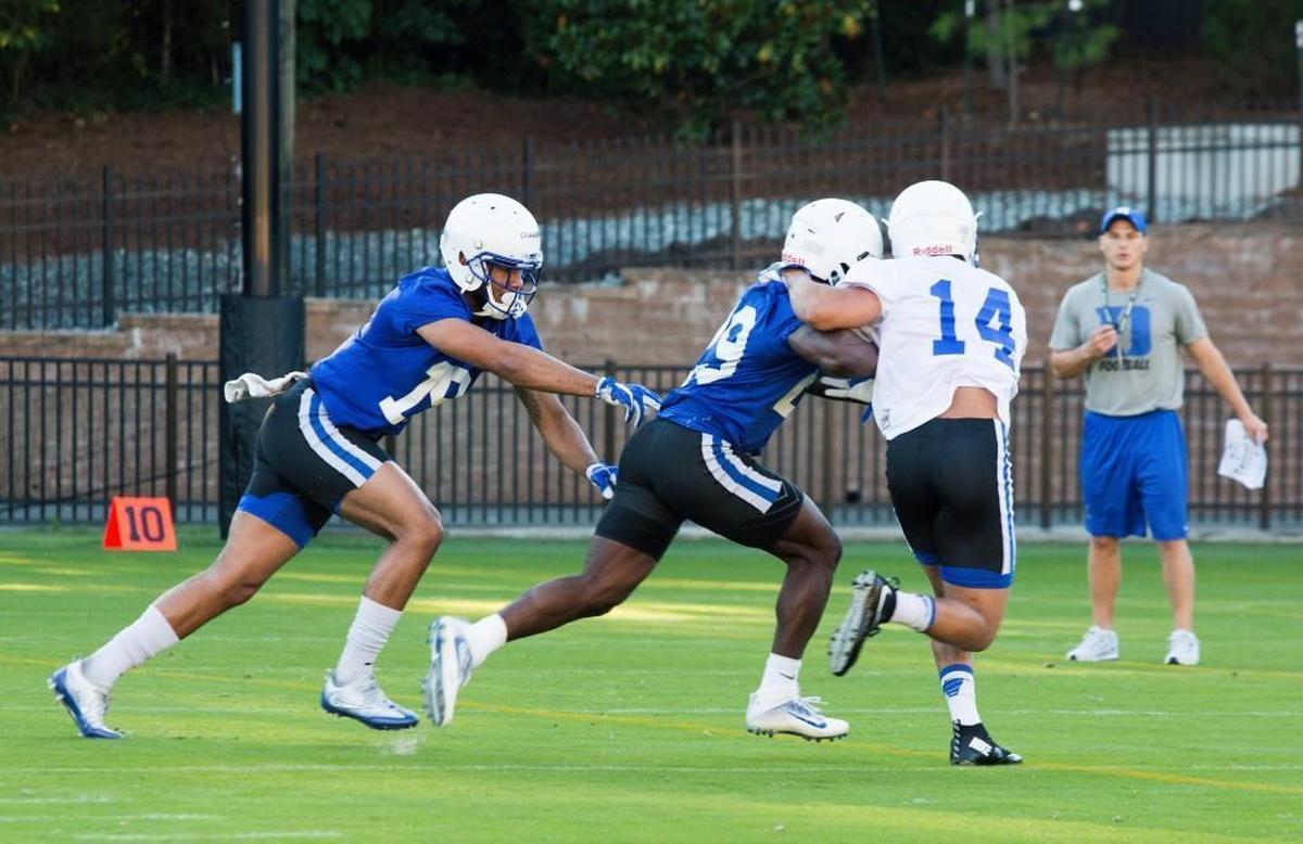 Quay Chambers, left, Shaun Wilson and Bryon Fields Jr. run a drill during the first Duke football practice on Monday.