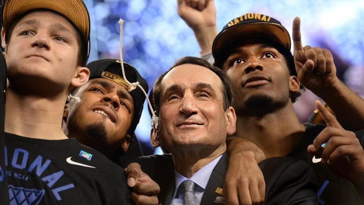 Mike Krzyzewski stands with, left to right, guard Grayson Allen, guard Quinn Cook and forward Justise Winslow as they watch “One Shining Moment” after Duke defeated Wisconsin 68-63 for the NCAA national championship on April 6, 2015.