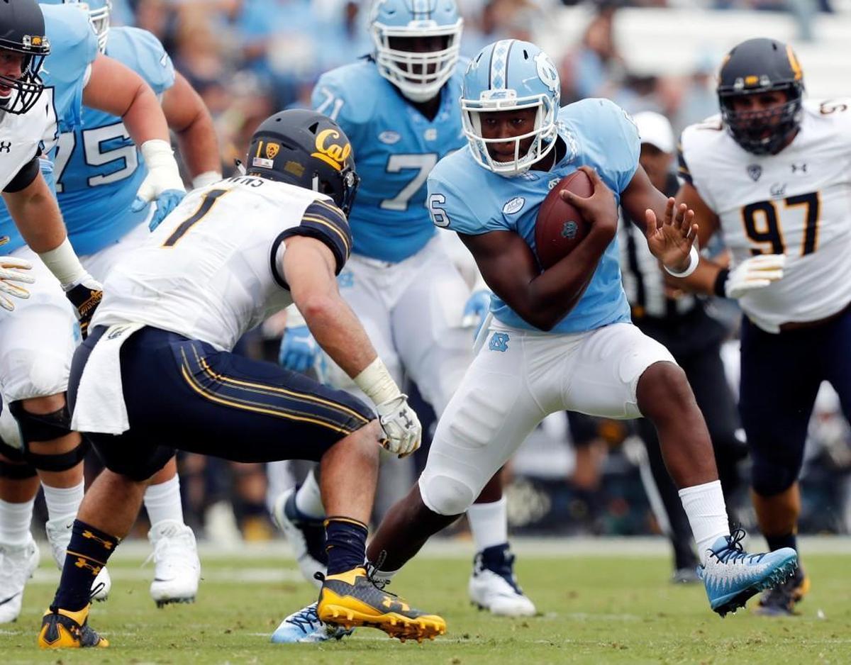UNC’s Brandon Harris runs the ball as California’s Devante Downs, left, closes in on him on Saturday.