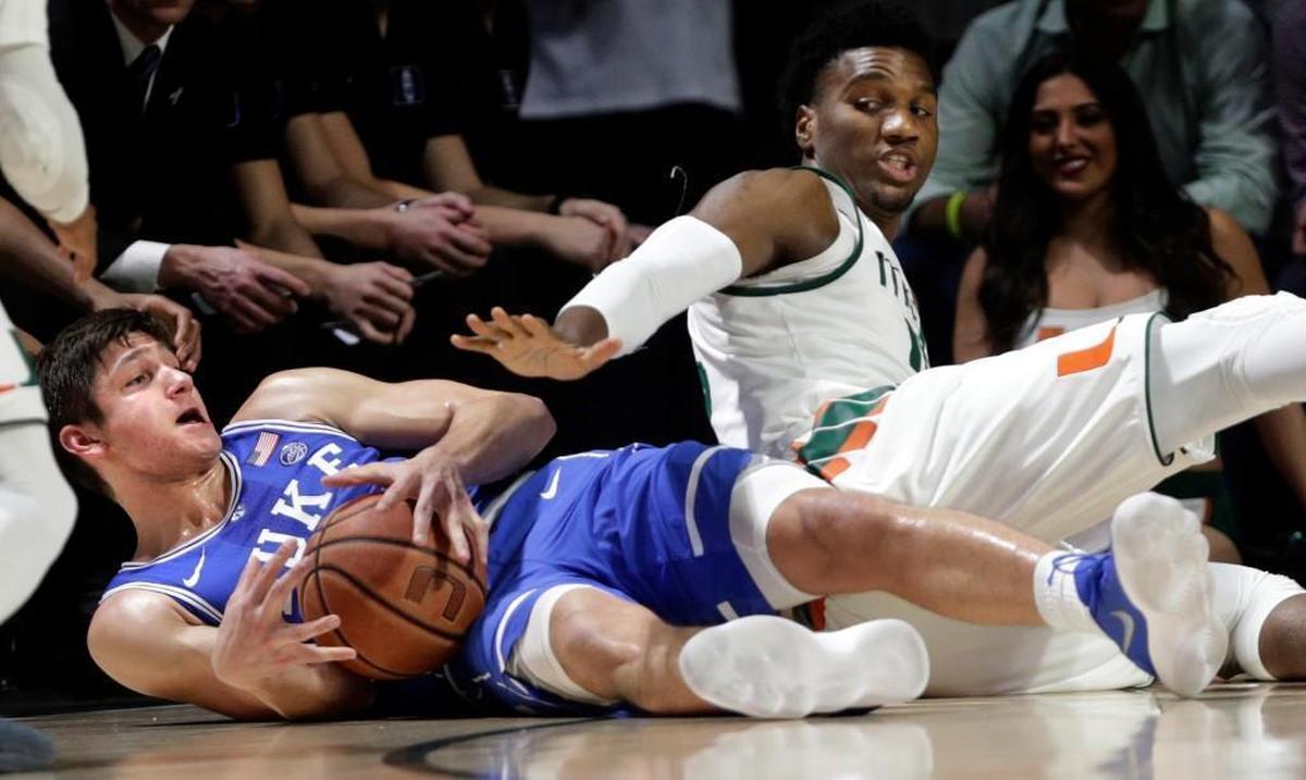 Duke's Grayson Allen, left and Miami's Ebuka Izundu go for the ball during the first half.