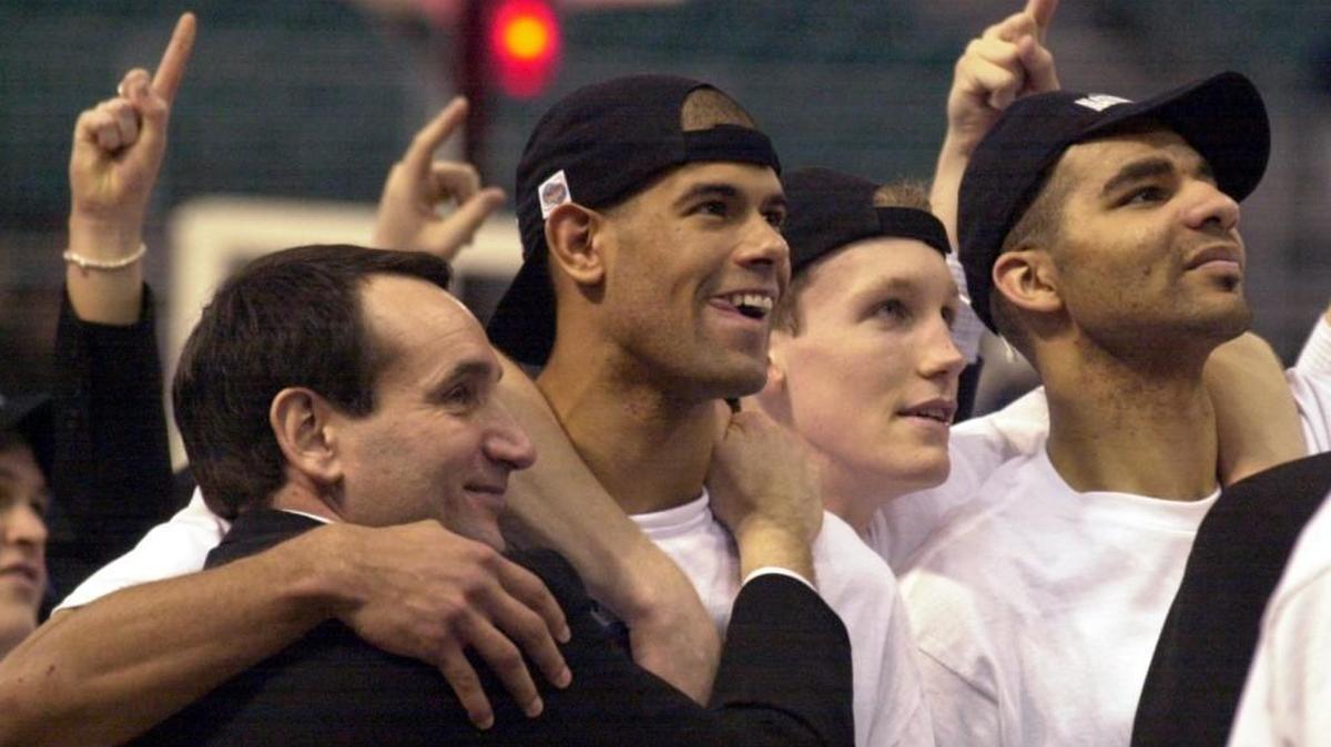 Duke coach Mike Krzyzewski hugs Shane Battier as Mike Dunleavy, and Carlos Boozer watch a video following the trophy presentation after the Blue Devils 82-72 NCAA championship win over Arizona in 2001.