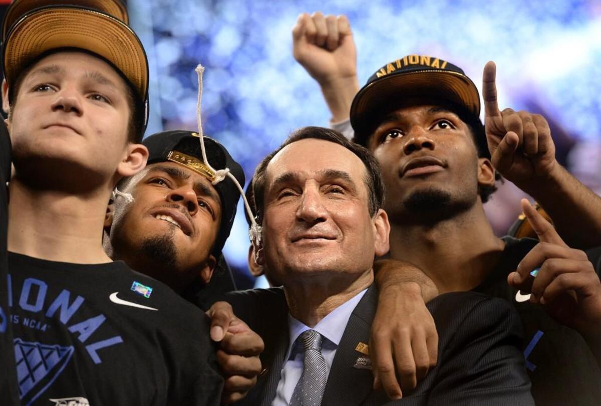 Duke head coach Mike Krzyzewski stands with, left to right, guard Grayson Allen, guard Quinn Cook and forward Justise Winslow after beating Wisconsin 68-63 for the 2015 NCAA national championship.