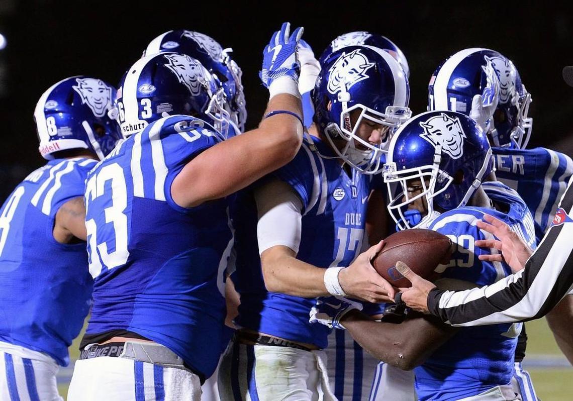 Duke quarterback Daniel Jones (17) is mobbed by teammates after scoring a touchdown against North Carolina last November.
