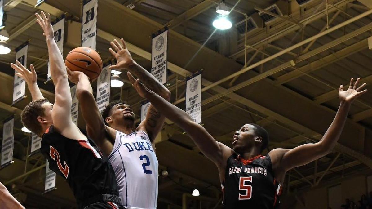 Duke Blue Devils guard Gary Trent Jr (2) shoots over guard Scott Meredith (2) and center Daniel Wallace (5) in the first half of play against St. Francis (Pa.) at Cameron Indoor Stadium in Durham on Tuesday, Dec. 5, 2017.