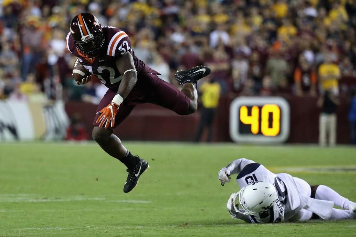 Virginia Tech running back Steven Peoples, left, is tripped up by West Virginia safety Toyous Avery on Sunday.