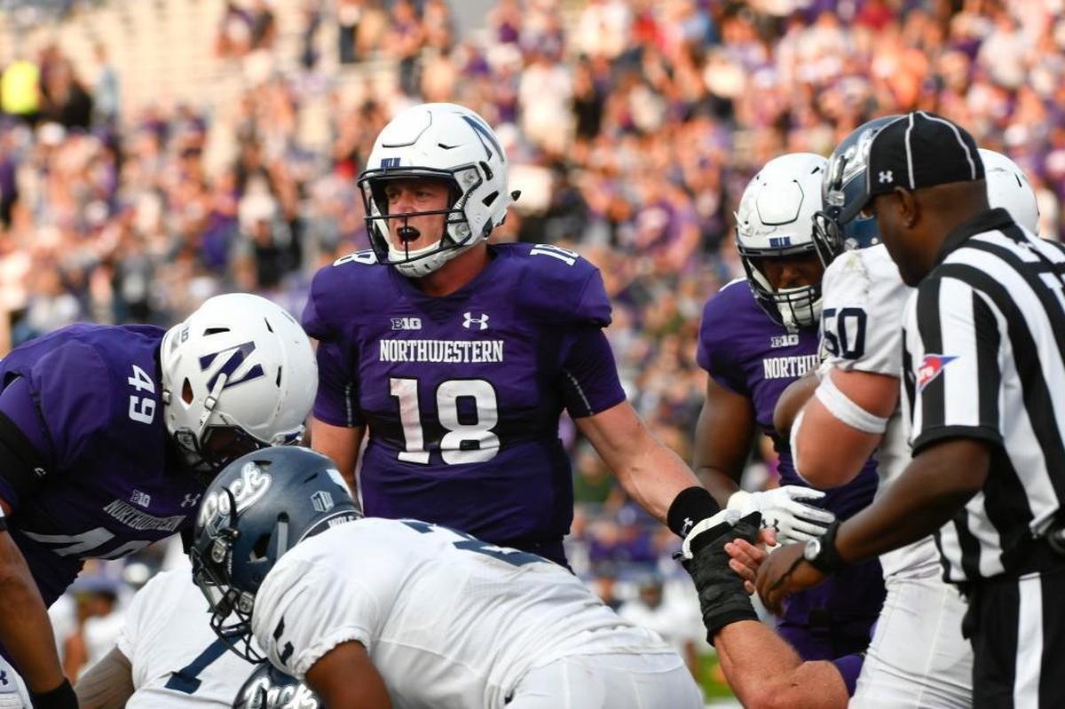 Northwestern quarterback Clayton Thorson, middle, celebrates after scoring a touchdown against Nevada on Saturday.