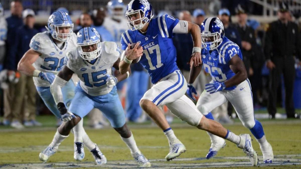 Duke quarterback Daniel Jones (17) heads for a first down in the third quarter as North Carolina safety Donnie Miles (15) pursues. Duke beat North Carolina 28-27 at Wallace Wade Stadium on Nov. 10, 2016.