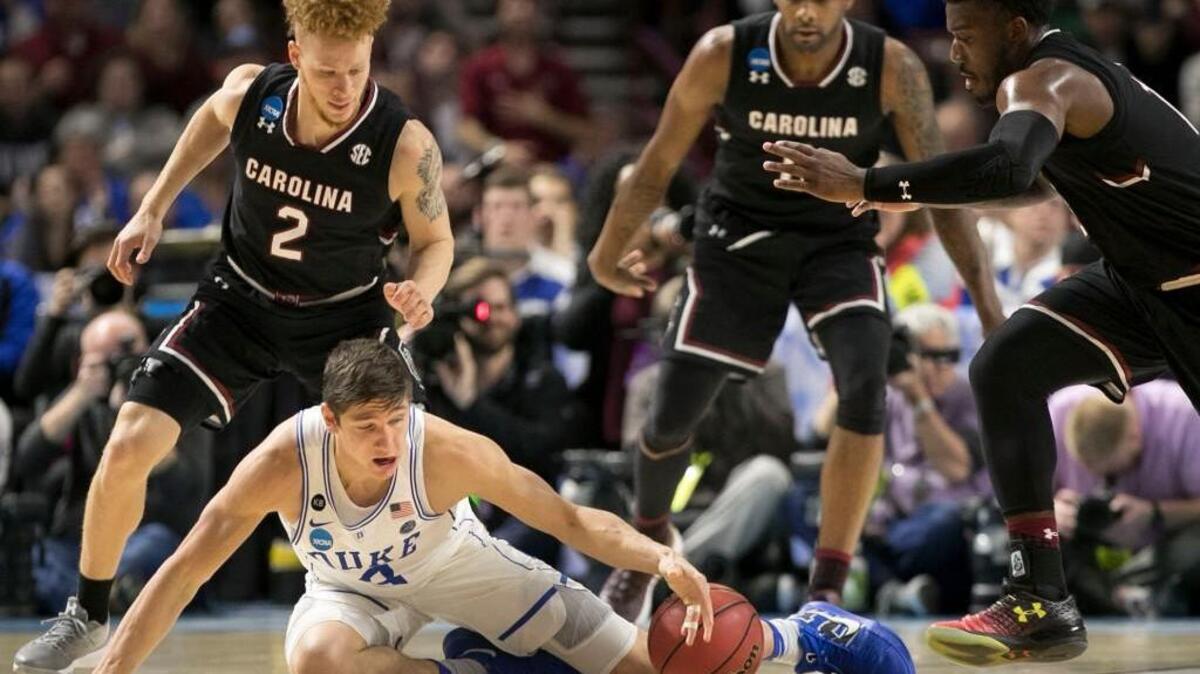 Duke’s Grayson Allen (3) is surrounded by South Carolina’s Hassani Gravett (2), Sindarius Thornwell (0) and Duane Notice (10) as he loses the basketball during the Gamecocks’ 88-81 win over the Blue Devils in the second round of the NCAA tournament on Sunday.