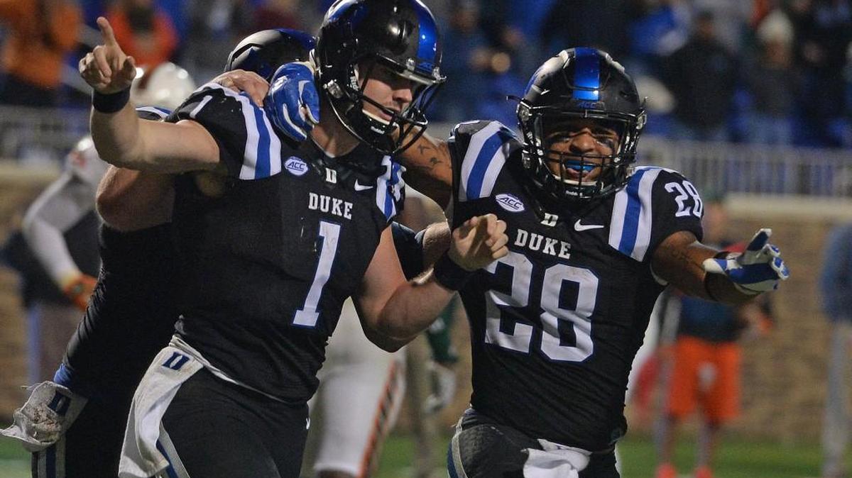 Duke quarterback Thomas Sirk, left and teammate running back Shaquille Powell (28) celebrate after Sirk scored a touchdown with six seconds left against Miami in October. The Blue Devils face Indiana Saturday, in the Pinstripe Bowl in New York, a destination that’s easy for players’ families to travel to.