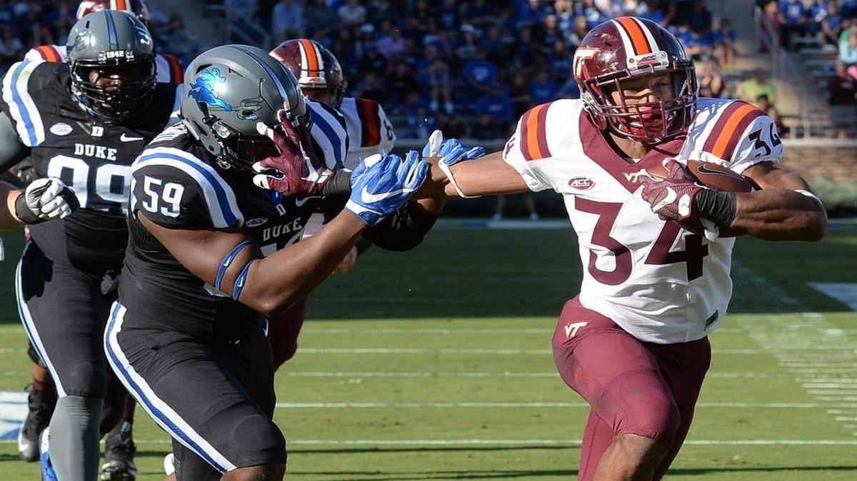 Virginia Tech running back Travon McMillian (34) stiff arms Duke defensive end James Hornbuckle (59) on the way to a first quarter score at Wallace Wade Stadium.