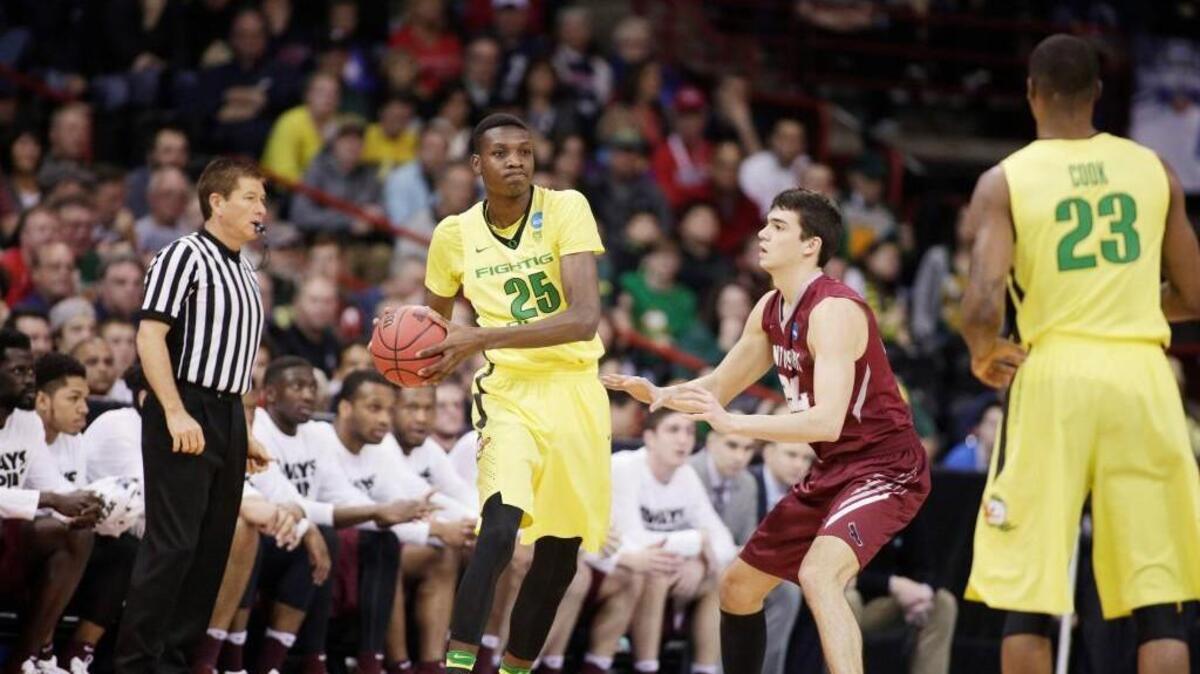 Oregon forward Chris Boucher (25) looks to pass while defended by Saint Joseph’s forward Pierfrancesco Oliva on March 20.