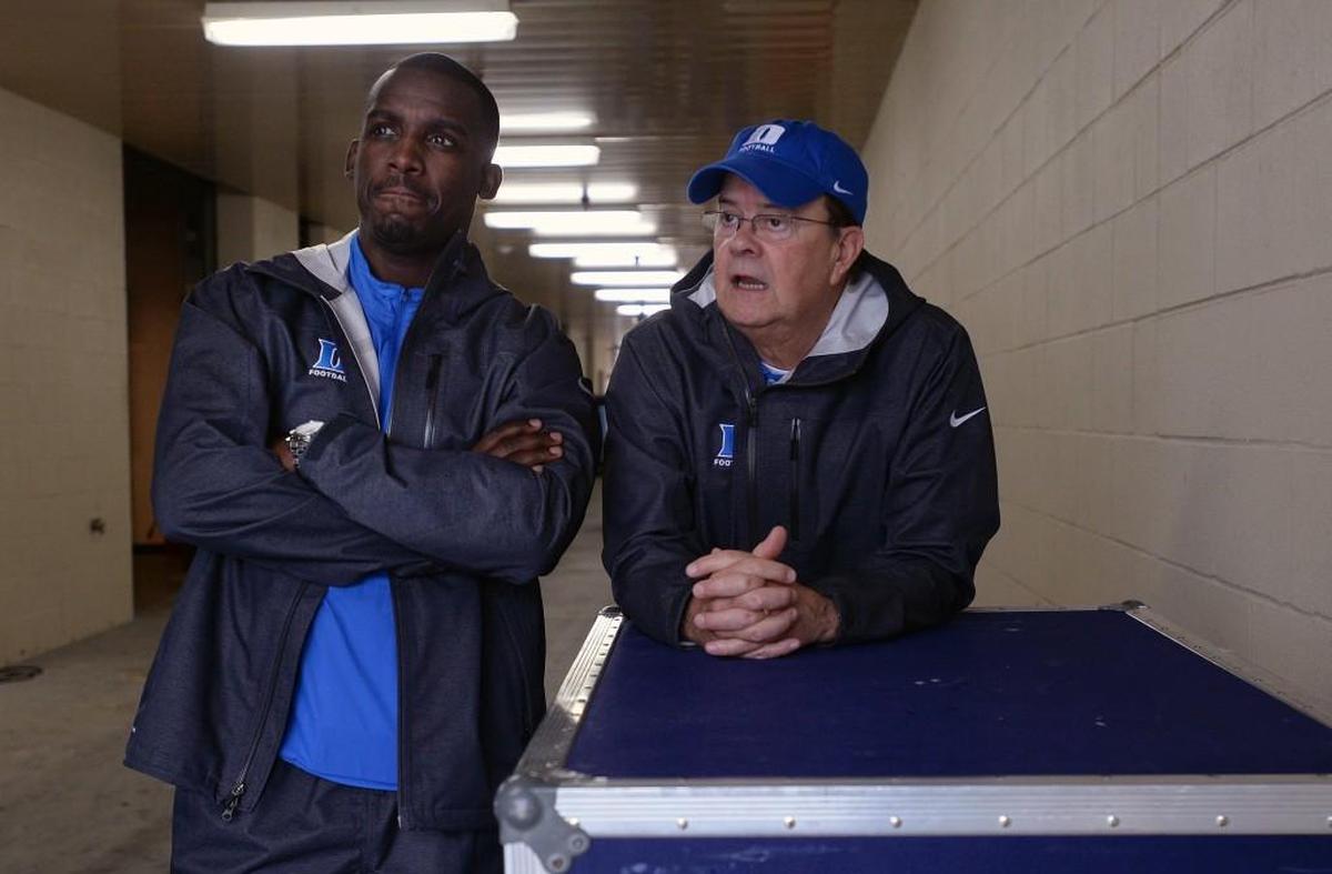 Duke offensive co-ordinator Scottie Montgomery, left, and head coach David Cutcliffe watch as rain falls at Kenan Stadium in 2015.