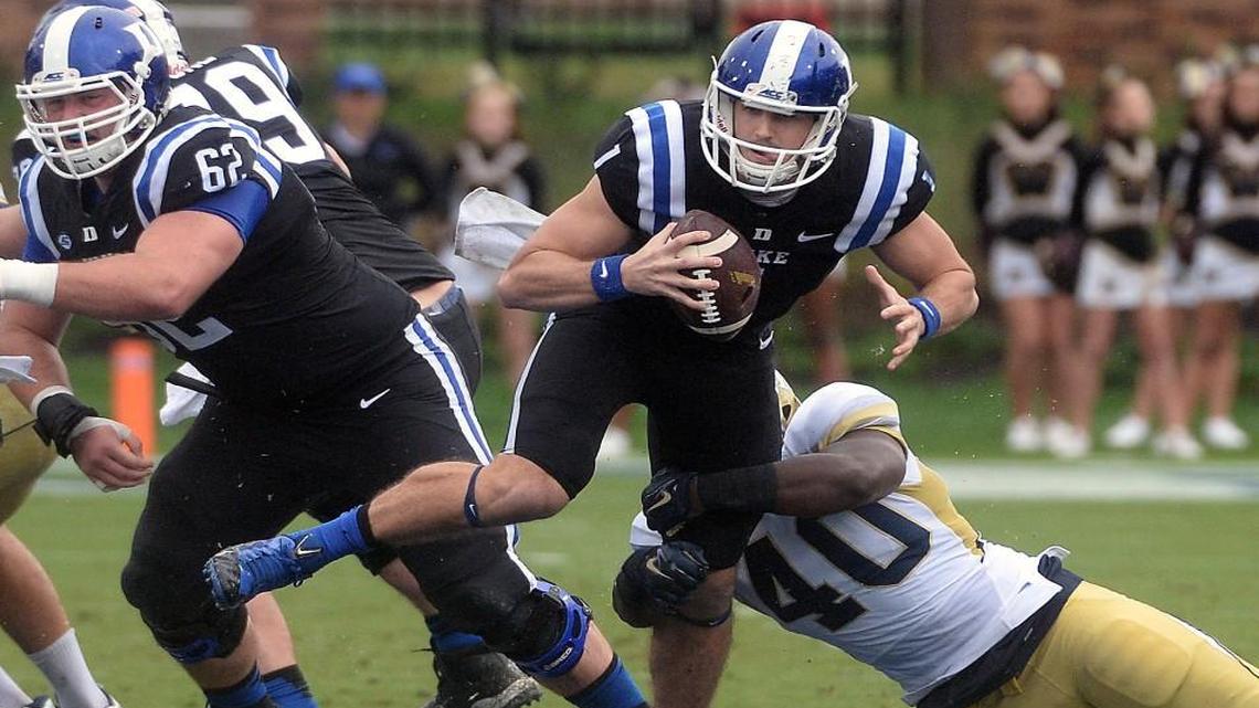 Duke quarterback Thomas Sirk (1) looks for a first down as Georgia Tech linebacker P.J. Davis (40) tries to pull him down during Duke’s 34-20 victory Saturday, September 26, 2015 at Wallace Wade Stadium in Durham.
