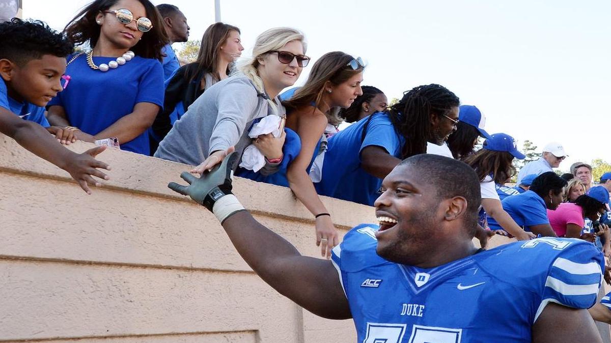 
Duke offensive guard Laken Tomlinson is congratulated by fans after the Blue Devils beat Virginia at Wallace Wade Stadium in Durham, Sept. 18, 2014.
