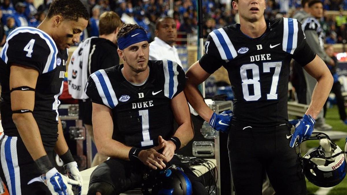 Duke wide receiver Johnell Barnes (4), quarterback Thomas Sirk (1) and wide receiver Max McCaffrey (87) sit as Miami's kick-off return is reviewed by game officials at Wallace Wade Stadium in Durham.