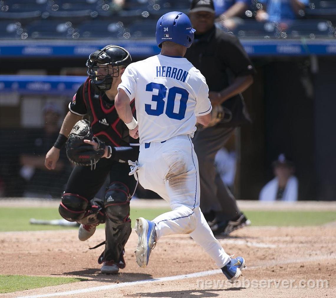 Duke’s Jimmy Herron (30) runs ahead of the throw to Louisville catcher Zach Britton (34) to score on a RBI by Chris Proctor in the fifth inning during the ACC Championship on Friday, May 25, 2018 at Durham Bulls Athletic Park in Durham, N.C.