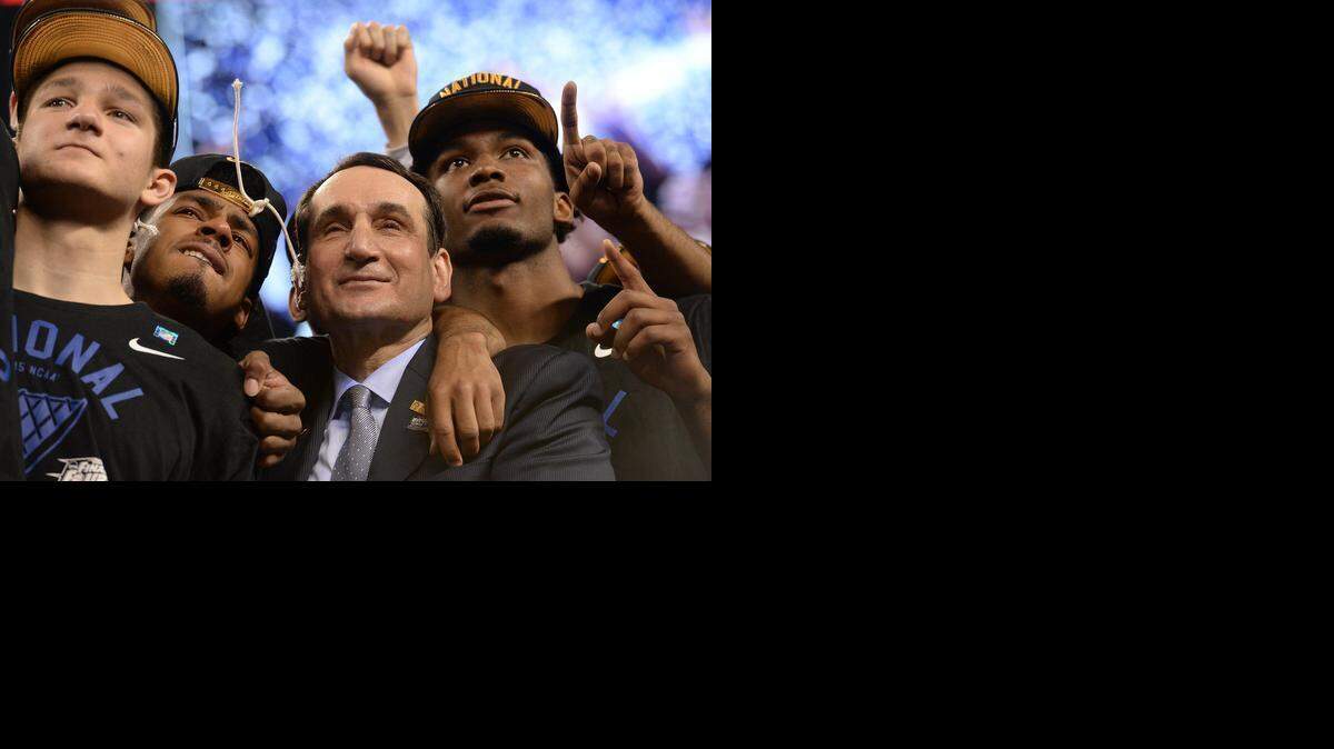 Duke coach Mike Krzyzewski stands with, left to right, Grayson Allen, Quinn Cook and Justise Winslow as they watch "One Shining Moment" after the Blue Devils defeated Wisconsin 68-63 for the NCAA national championship at Lucas Oil Stadium at Indianapolis.