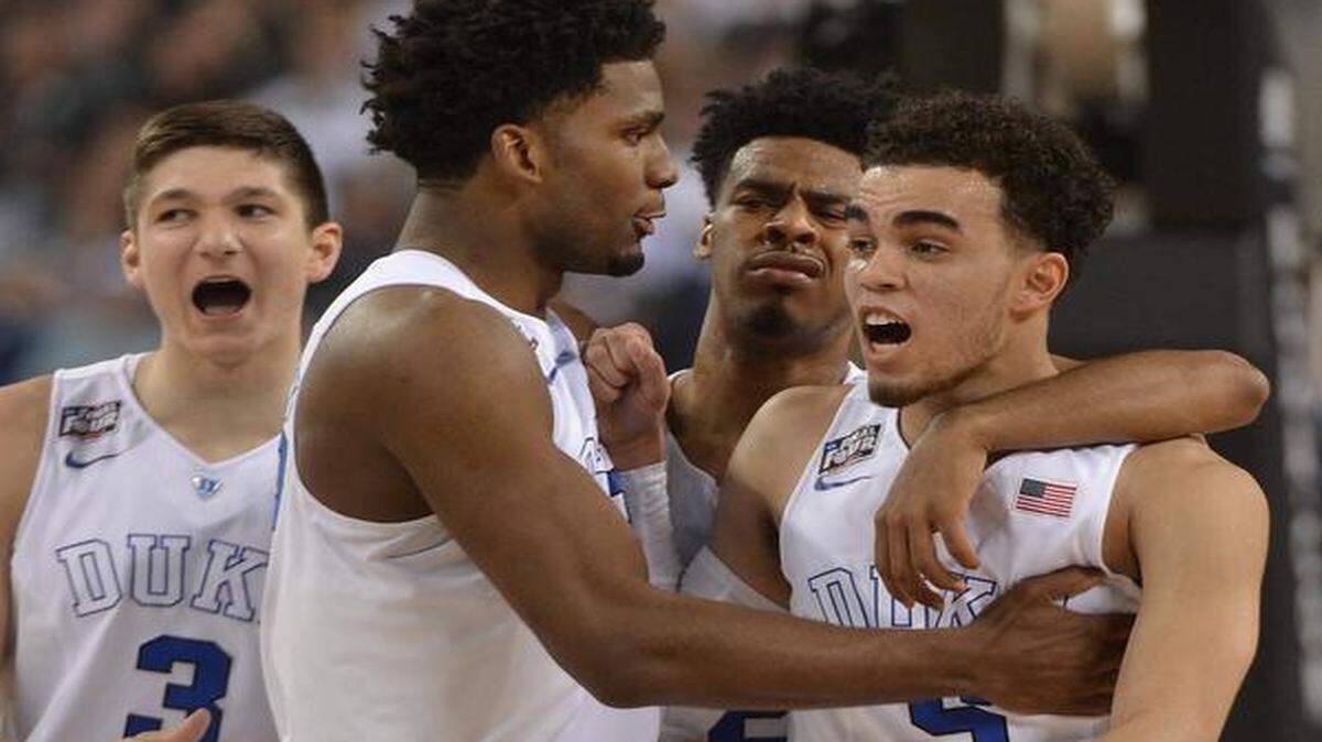 
Duke’s Grayson Allen (3), Justise Winslow, Quinn Cook (2) surround guard Tyus Jones (5) after he is fouled in the first half of play against Michigan State during the semifinal game of the NCAA Final Four at Lucas Oil Stadium in Indianapolis.
