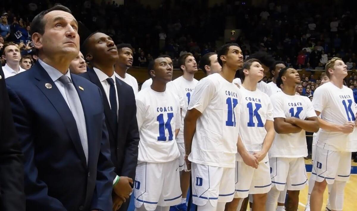 Blue Devils head coach Mike Krzyzewski and his team watch the video screen during a ceremony honoring Coach K after Duke defeated Utah Valley 99-69. Duke's head coach won his 1000th game as the leader of the Blue Devils at Cameron Indoor Stadium in Durham on Nov. 11, 2017.