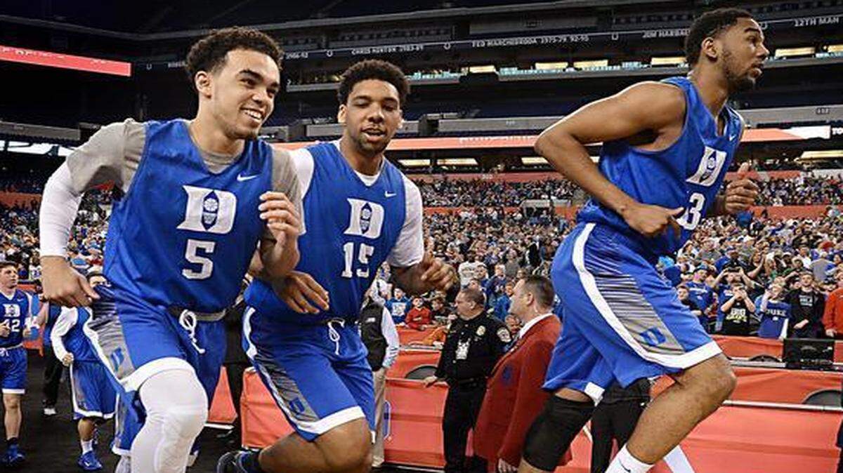
Duke’s Tyus Jones (5), Jahlil Okafor and Matt Jones run onto the court at Lucas Oil Stadium in Indianapolis as they prepare to practice for their semi-final tilt against Michigan State on Saturday.
