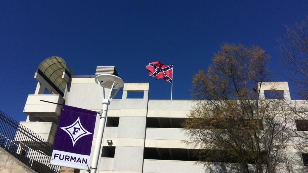 A confederate flag flies over a parking deck next to Bon Secours Wellness Arena in Greenville, S.C., where Duke and UNC are playing in the NCAA tournament.
