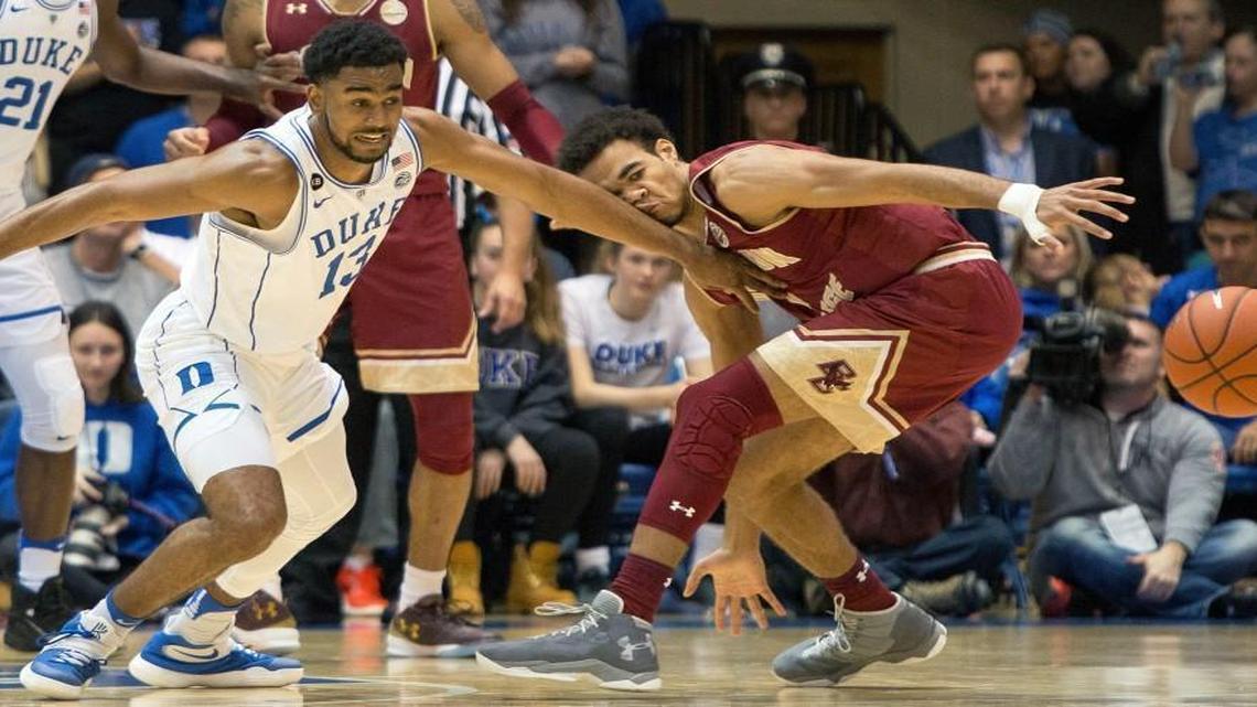 Duke's Matt Jones (13) and Boston College's Jerome Robinson, right, chase after a loose ball during the first half in Durham.