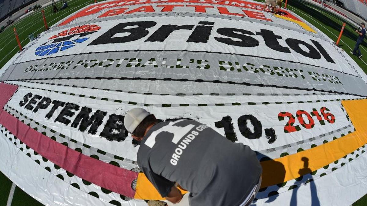 Members of the University of Tennessee grounds crew paint the logo on the football field at Bristol Motor Speedway in Bristol, Tenn. More than 150,000 are expected to attend “Battle at Bristol” for the Virginia Tech-Tennessee game there Saturday. The largest attendance record for a college football game is 115,109, set at Michigan in 2013.