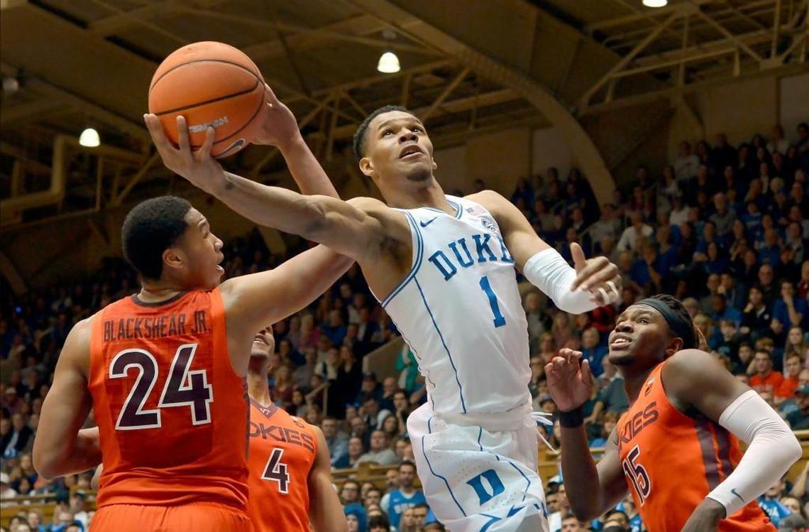 Duke guard Trevon Duval (1) goes in for a first half shot as Virginia Tech forward Kerry Blackshear Jr. (24) and Virginia Tech forward Chris Clarke (15) defend. Duke battled Virginia Tech at Cameron Indoor Stadium in Durham, N.C., Wednesday, Feb. 14, 2018.