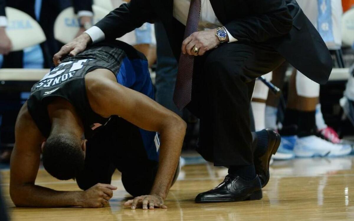 Duke head coach Mike Krzyzewski checks on an injured Duke guard Matt Jones after the junior guard sprained his ankle in the first half on the Blue Devils’ win over UNC Wednesday.