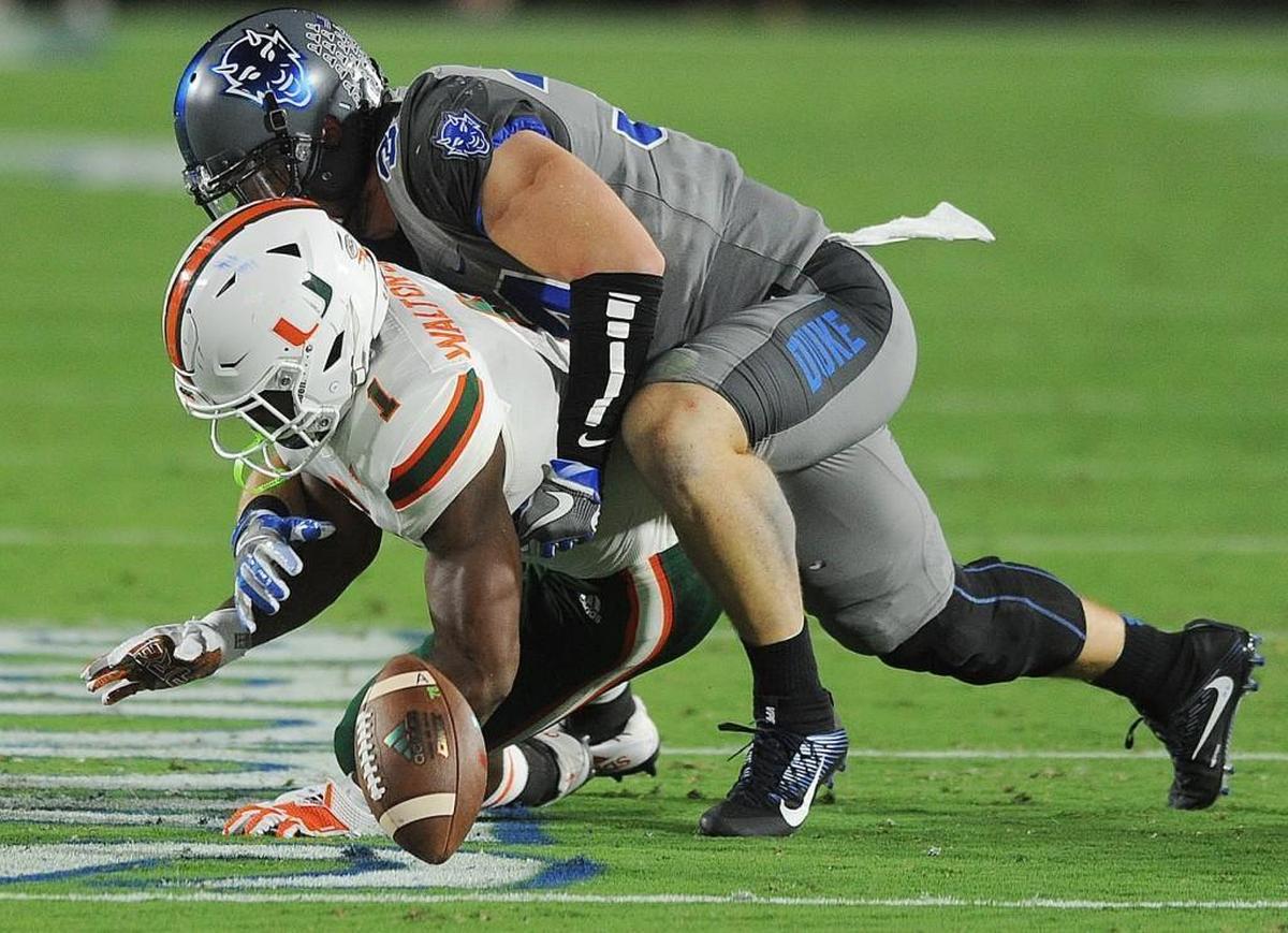 Duke's Ben Humphreys takes down Miami's Mark Walton (1), Friday, September 29, 2017, in Wallace Wade Stadium.