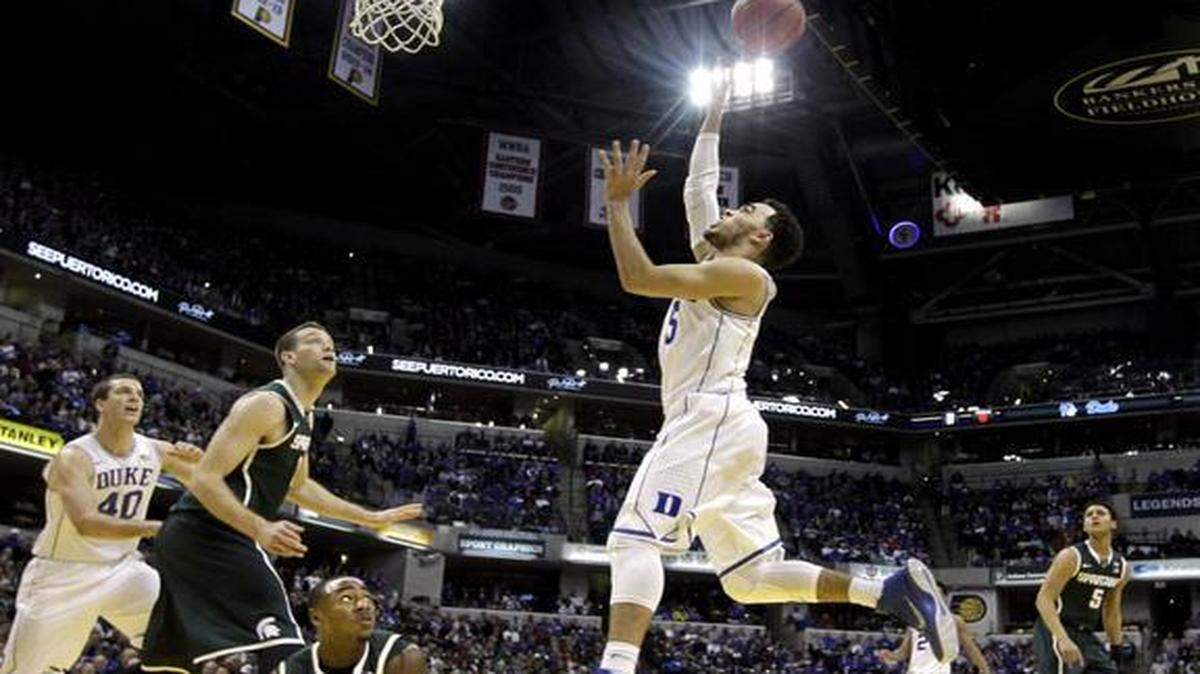 
Duke's Tyus Jones puts up a shot as Michigan State's Lourawls Nairn Jr., on floor,  watches during the teams’ first meeting in November. Duke won 81-71. 
