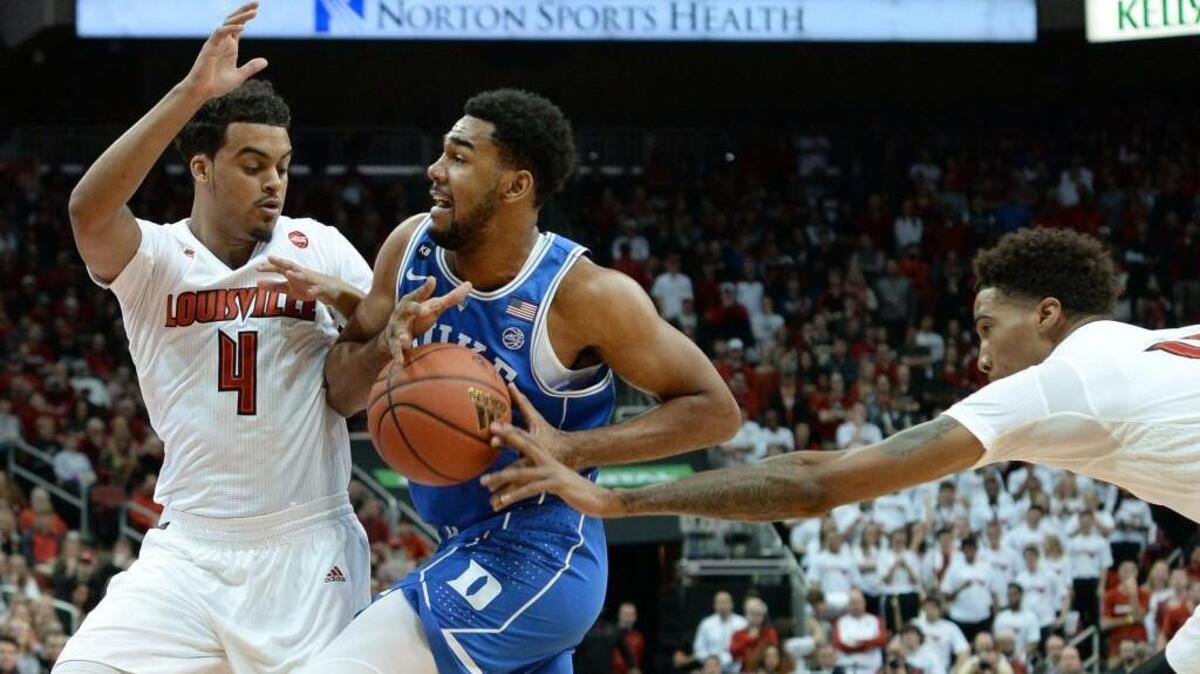Duke guard Matt Jones (13) gets the ball stripped from him by Louisville guard Jay Henderson (11) in the Cardinals’ 78-69 win over the Blue Devils on Jan. 14.