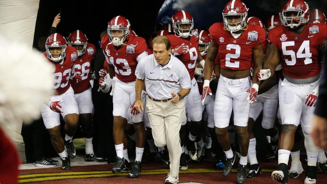 Alabama head coach Nick Saban and players enter the field for the first half of the Peach Bowl NCAA college football playoff game against Washington in Atlanta on Dec. 31, 2016. (AP Photo/John Bazemore)