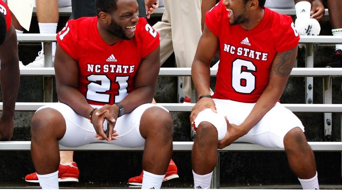 N.C. State running back Matthew Dayes, left, laughs with Niles Clark, right, before the media day team photo is taken on Aug. 7. The Wolfpack opens their season against William & Mary Thursday. The game will air online on ACC Network Extra.