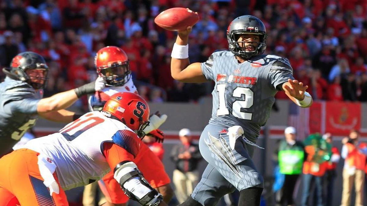 N.C. State quarterback Jacoby Brissett (12) looks to pass while under pressure from Syracuse's John Raymon (50) during their game at Carter-Finley Stadium in Raleigh on Saturday, Nov. 21, 2015.