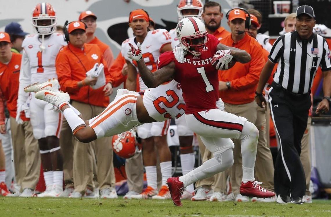 N.C. State’s Jaylen Samuels (1) tries to break free from Clemson safety Van Smith (23) during the first half of the game against Clemson at Carter-Finley Stadium in Raleigh on Saturday, Nov. 4, 2017.