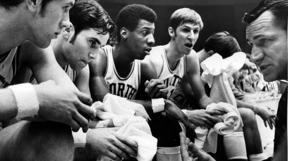 UNC coach Dean Smith (right) gives instructions to his players, including Charlie Scott, center, during a game in the 1969 ACC tournament.