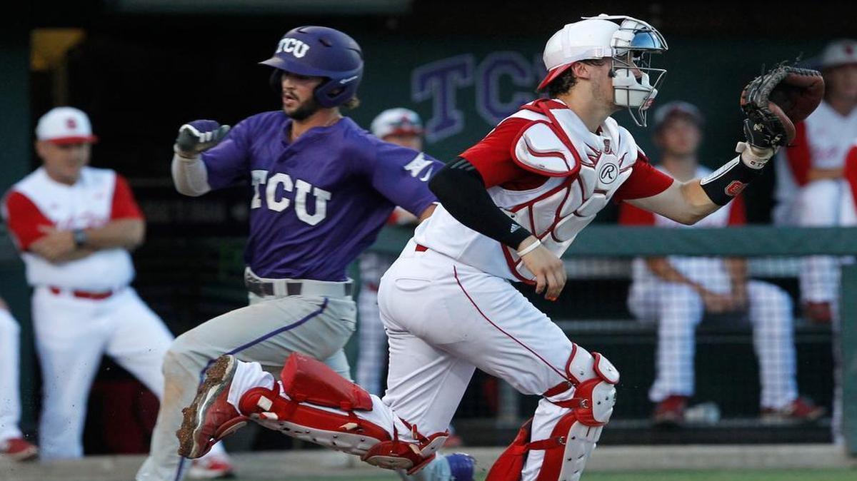 
TCU's Garrett Crain, left, runs past NC State catcher Andrew Knizner (11) to score in the third inning at the Fort Worth Regional of the NCAA college baseball tournament. 
