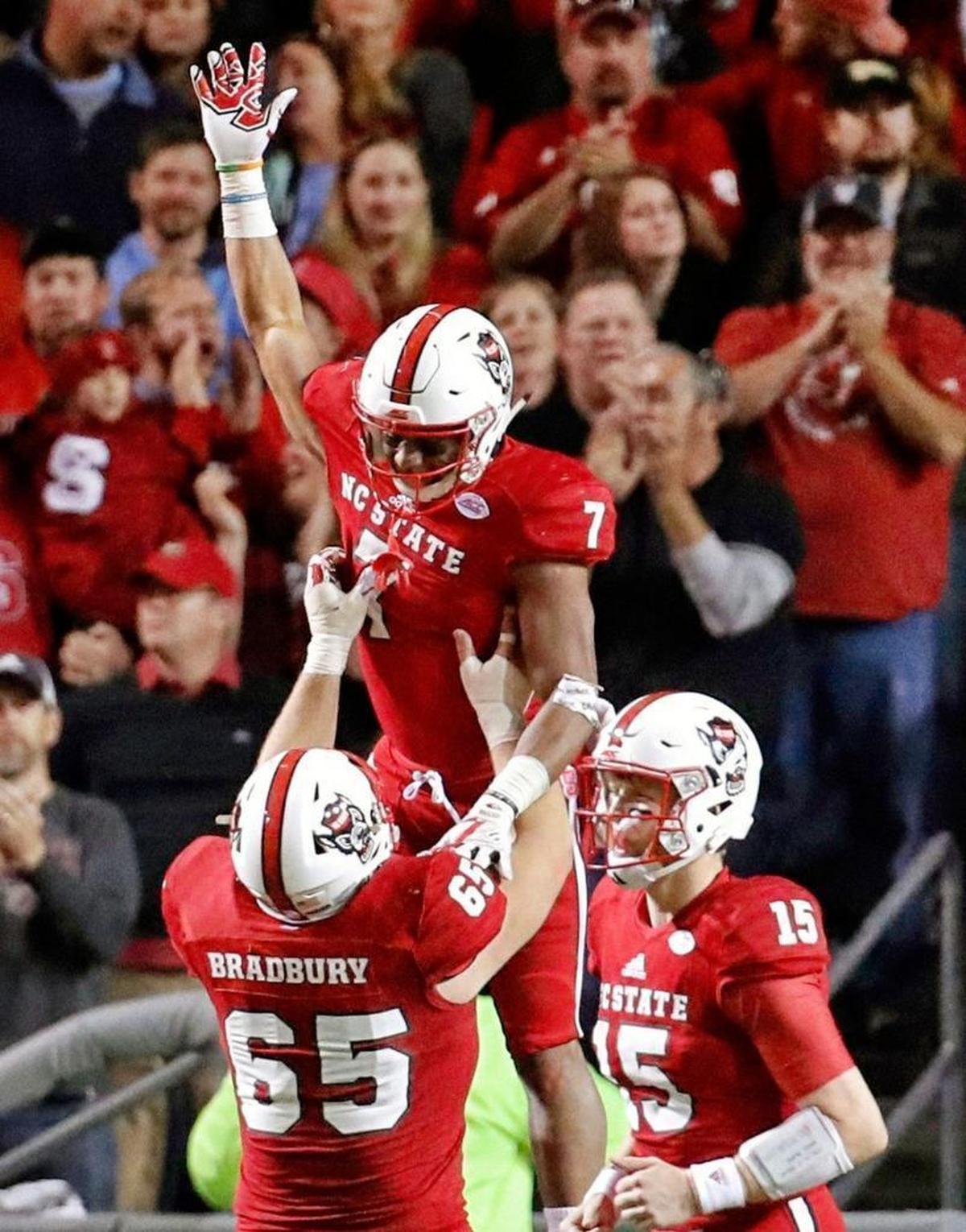 N.C. State's Nyheim Hines (7) celebrates his touchdown with Garrett Bradbury (65) and Ryan Finley (15 after he scored on a long run during the third quarter.