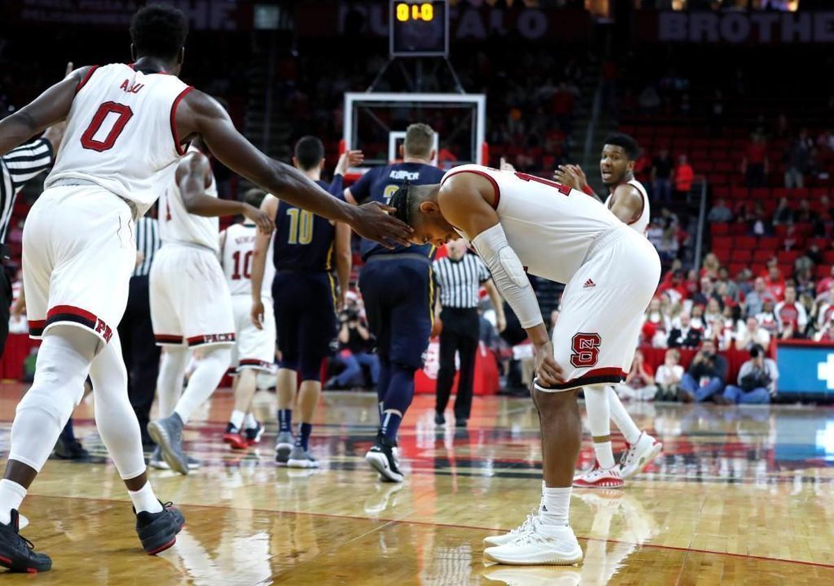 N.C. State's Abdul-Malik Abu (0) encourages Allerik Freeman (12) after Freeman turned the ball over with one second left in the game during UNCG's 81-76 at PNC Arena Saturday, Dec. 16, 2017.