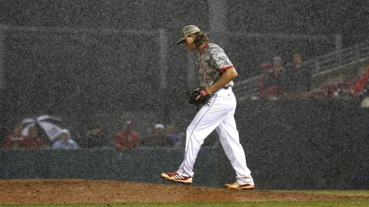 N.C. State's Evan Brabrand heads back to the mound in the rain in the ninth inning right before a weather delay during the Wolfpack's game against Coastal Carolina.