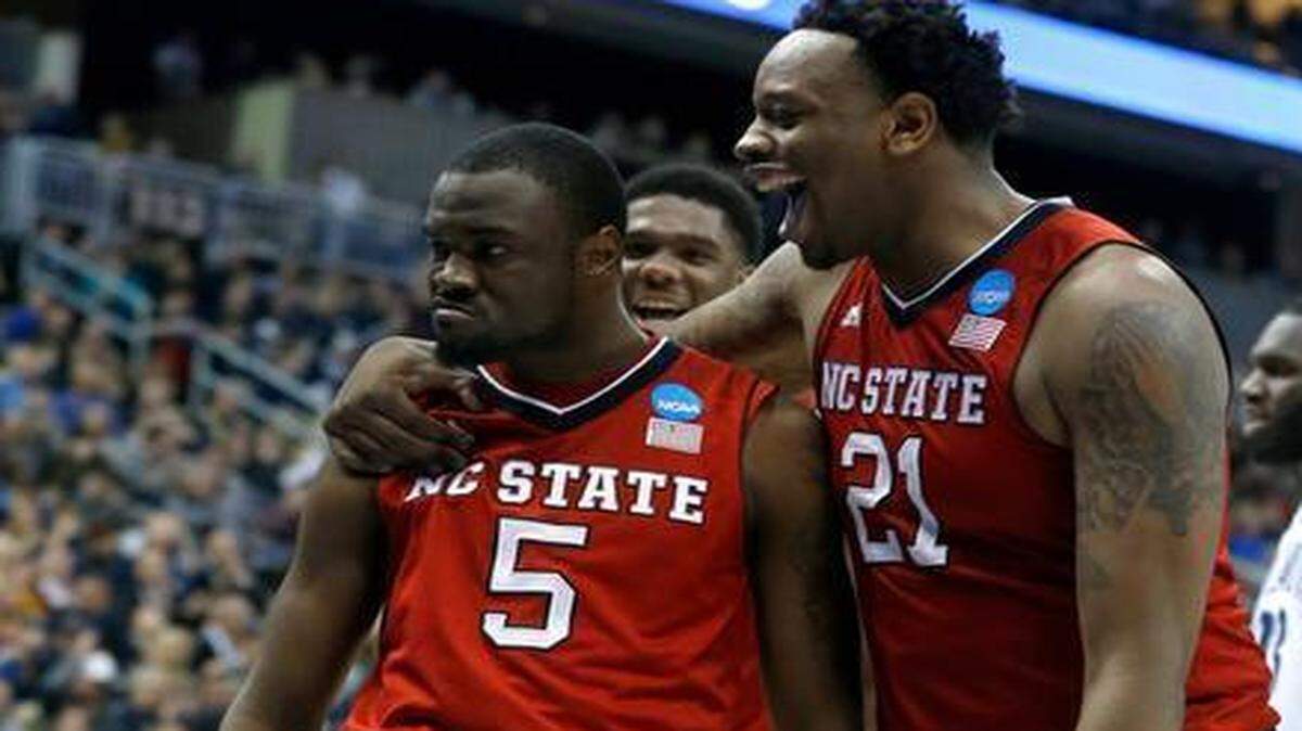 
N.C. State’s BeeJay Anya, right, congratulates Desmond Lee after Lee made a basket while being fouled during the second half of N.C. State’s 71-68 victory against Villanova in the third round of the NCAA tournament at the Consol Energy Center in Pittsburgh on Saturday.

