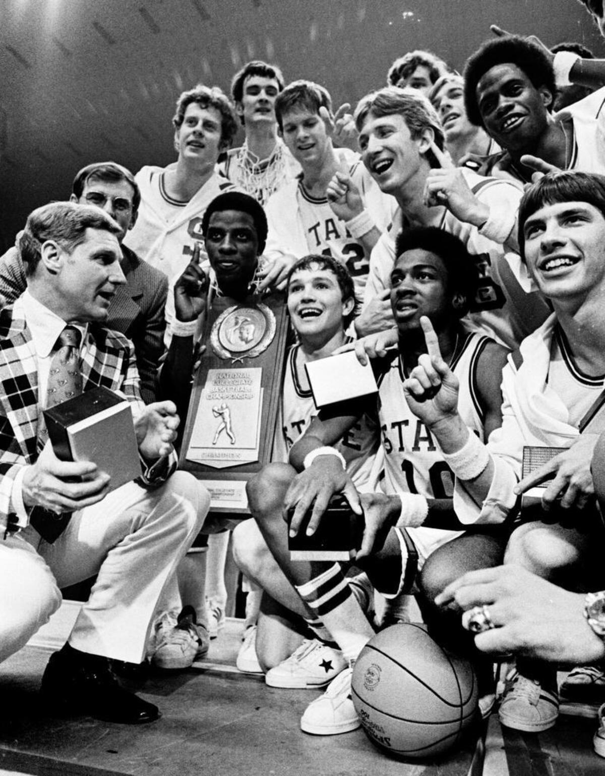 NC State players pose with coach Norm Sloan and the 1974 National Championship trophy after defeating Marquette.