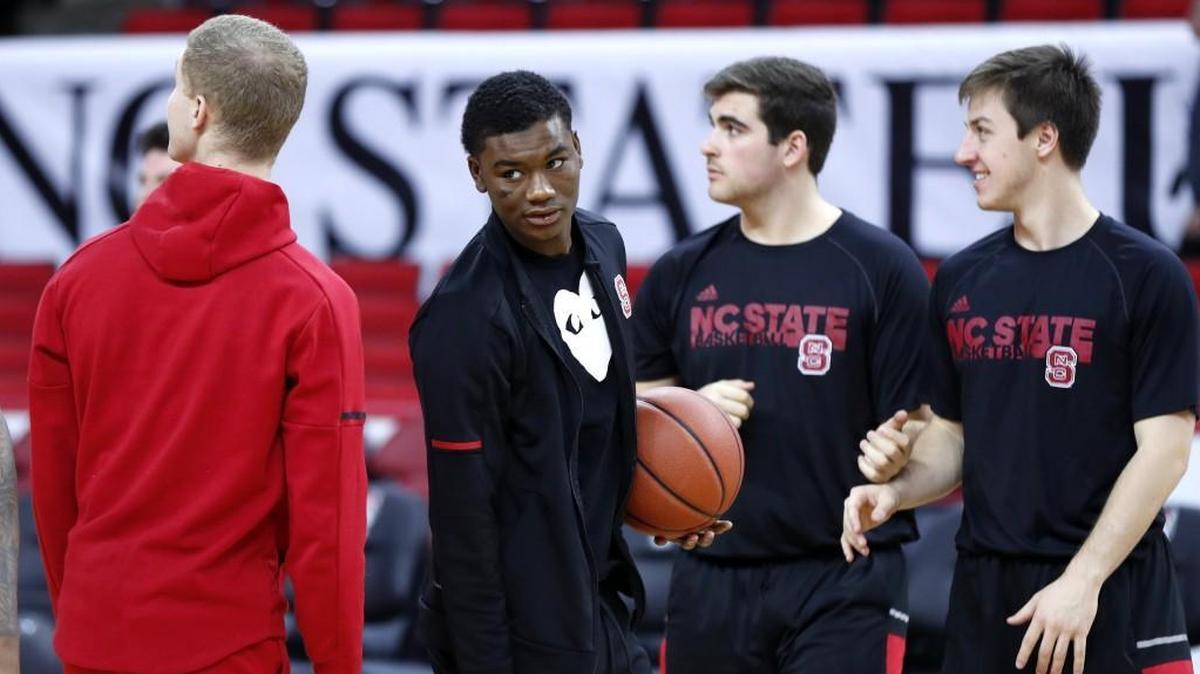 N.C. State’s Markell Johnson, center, did not dress for the Wolfpack’s game against UNCG on Dec. 16. He was suspended on Dec. 14 following his indictment for felony assault.