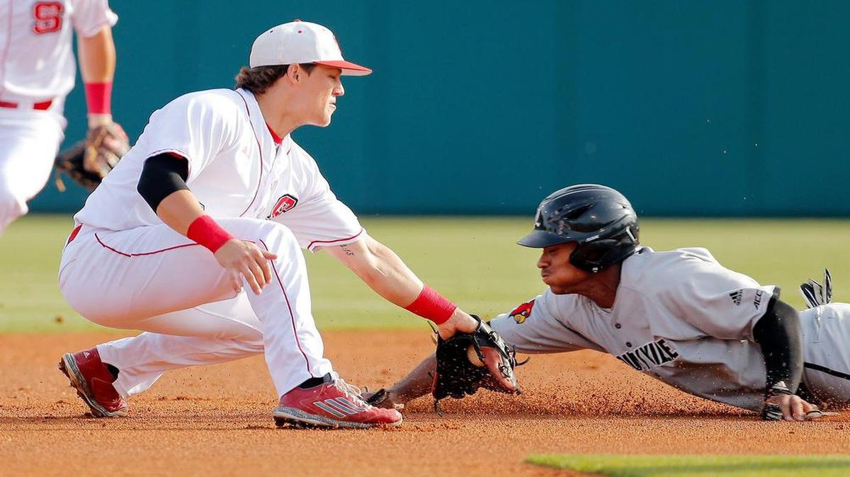
NC State's Logan Ratledge (6) tries to tag Louisville's Corey Ray (2) out as he slides into second during the first inning of an ACC college baseball game played between Louisville and N.C. State at Doak Field on the N.C. State campus in Raleigh on May 14, 2015. Ray was ruled safe.
