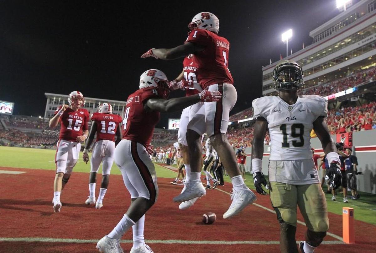 N.C. State's Jaylen Samuels (1) celebrates with Gavin Locklear (30) and Reggie Gallaspy II (4) after Samuels scored in the Wolfpack’s 48-14 victory over William & Mary on Sept. 1, 2016.